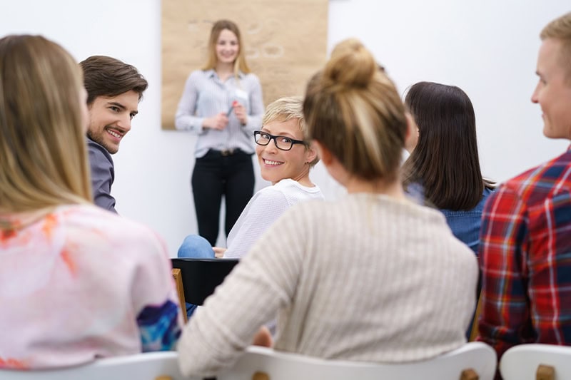 DISC foredrag for en gruppe glade mennesker som vil styrke teamwork på arbejdspladsen.